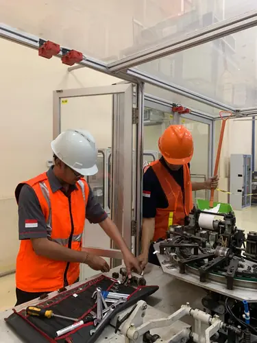 Teknisi Aldikarya memperbaiki mesin dengan komponen tertata di lapangan